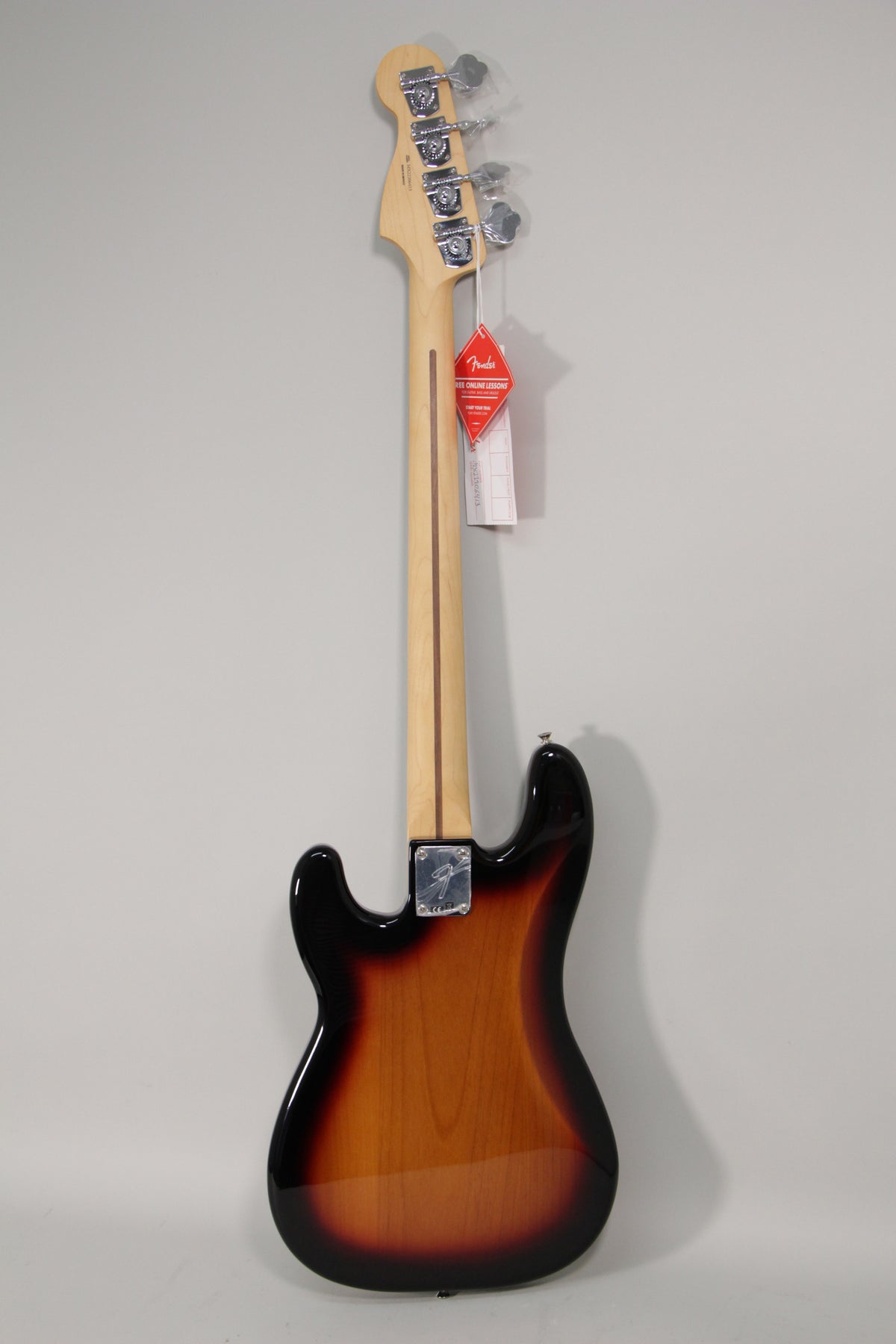 Full rear view of a sunburst bass guitar, showing the maple neck, chrome tuning machines, and neck plate.