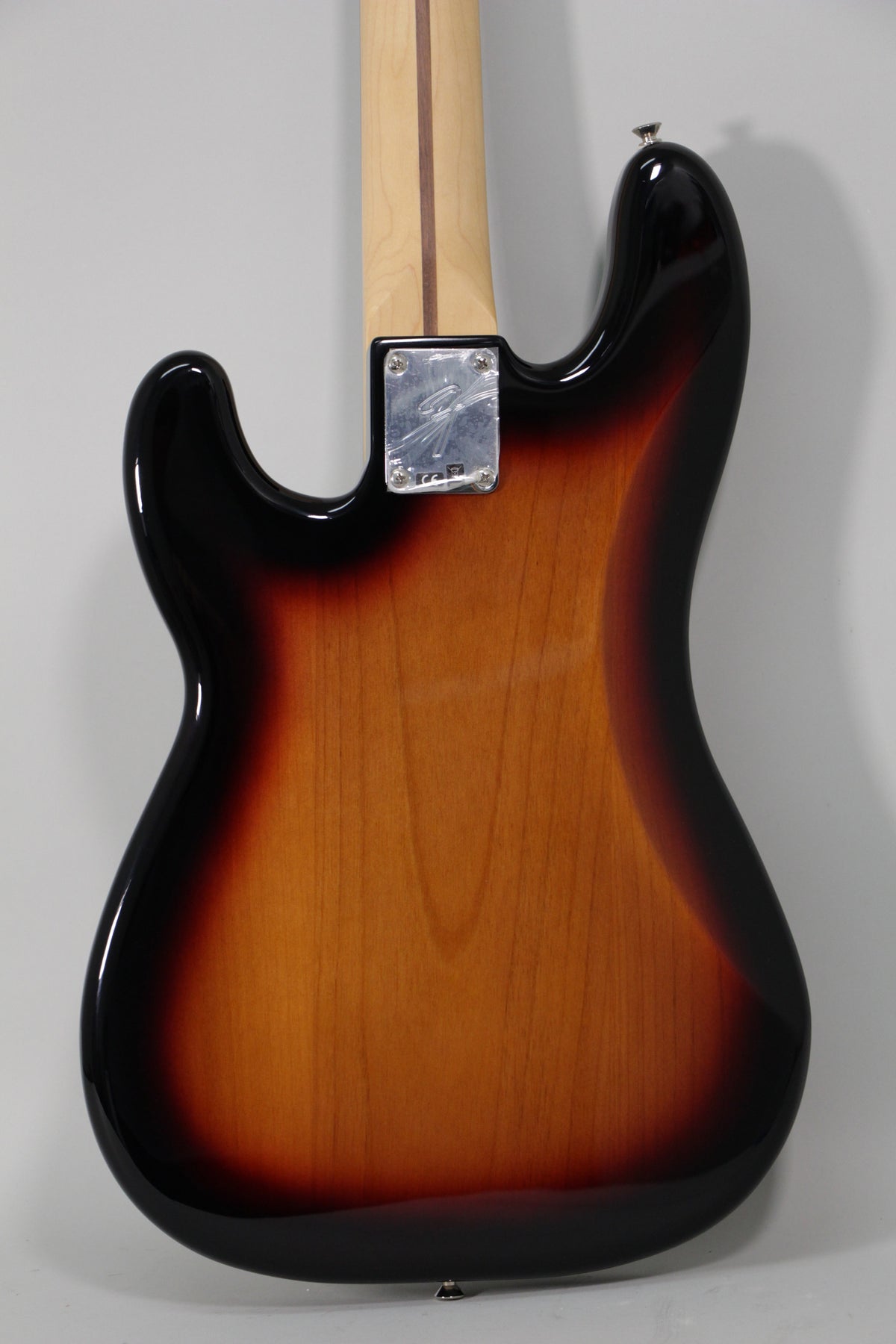 The back of the sunburst bass body, showing the neck plate, strap button, and a light wood neck with a dark stripe.