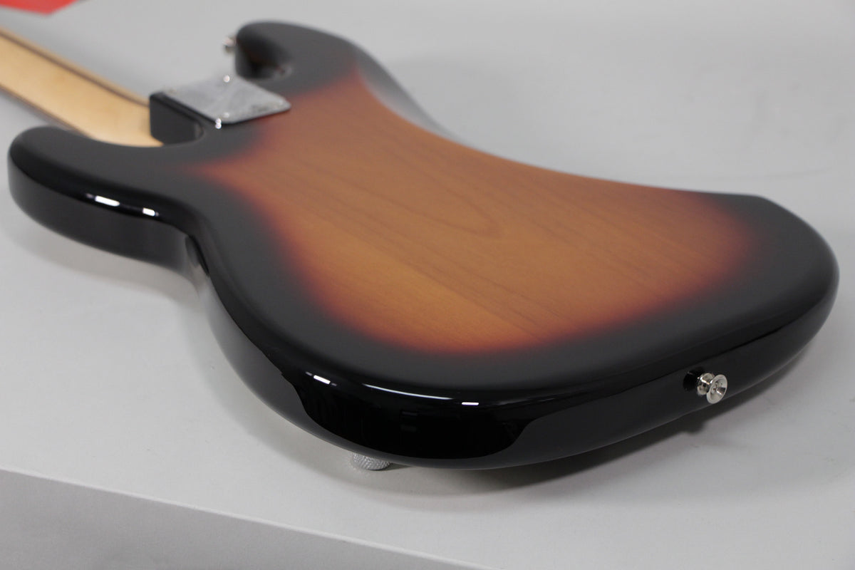 The bass body's back, in glossy sunburst, shows a chrome neck plate and strap button, with no visible wear.