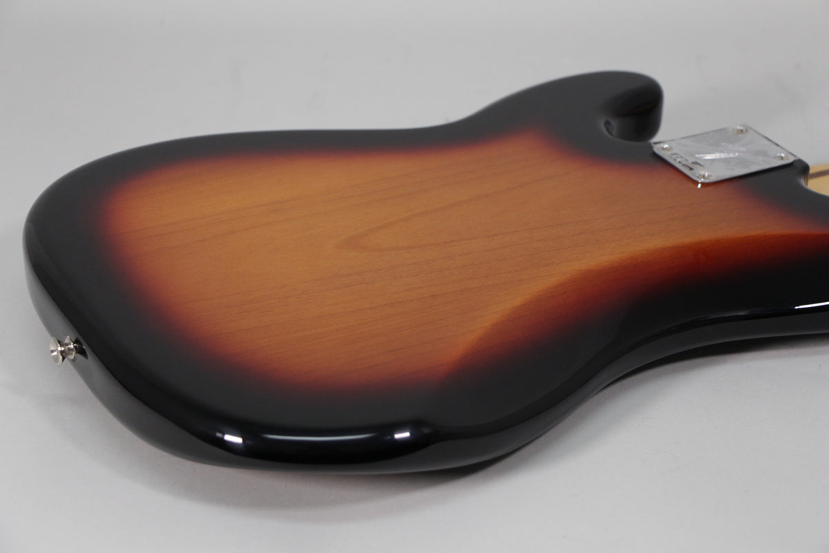 The back of a sunburst bass body, showing the glossy finish, chrome neck plate, and a strap button.