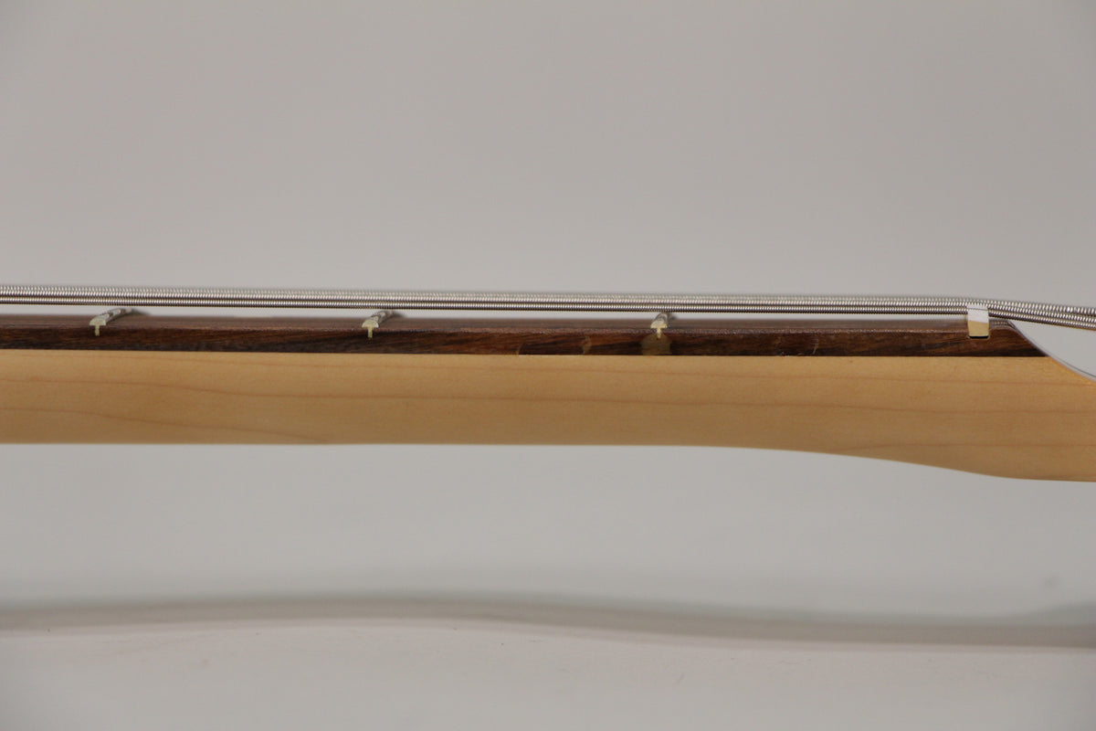 Close-up of the bass neck from the side, showing the light maple neck, dark rosewood fretboard, and four silver strings.