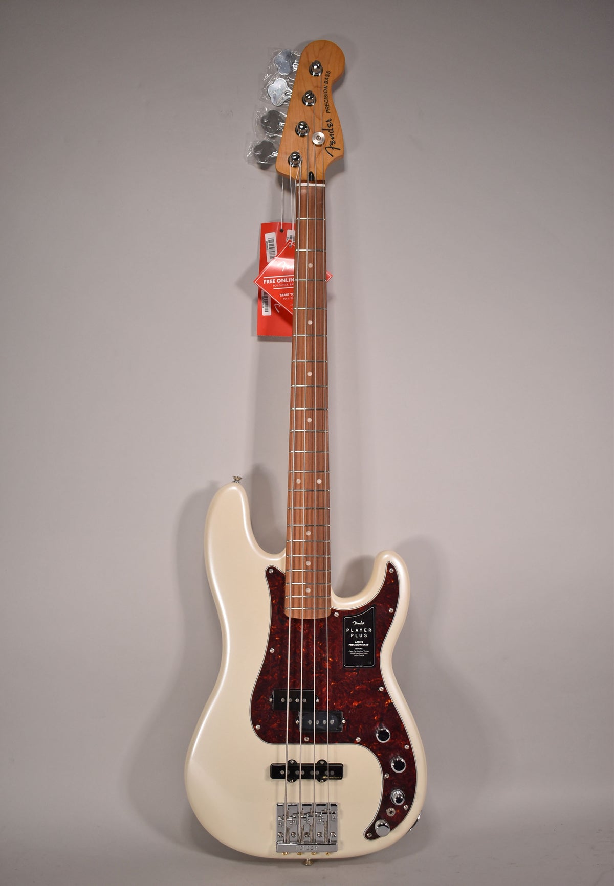 Full-length view of a cream-colored bass guitar with a tortoiseshell pickguard, chrome hardware, and a maple neck with a rosewood fretboard.