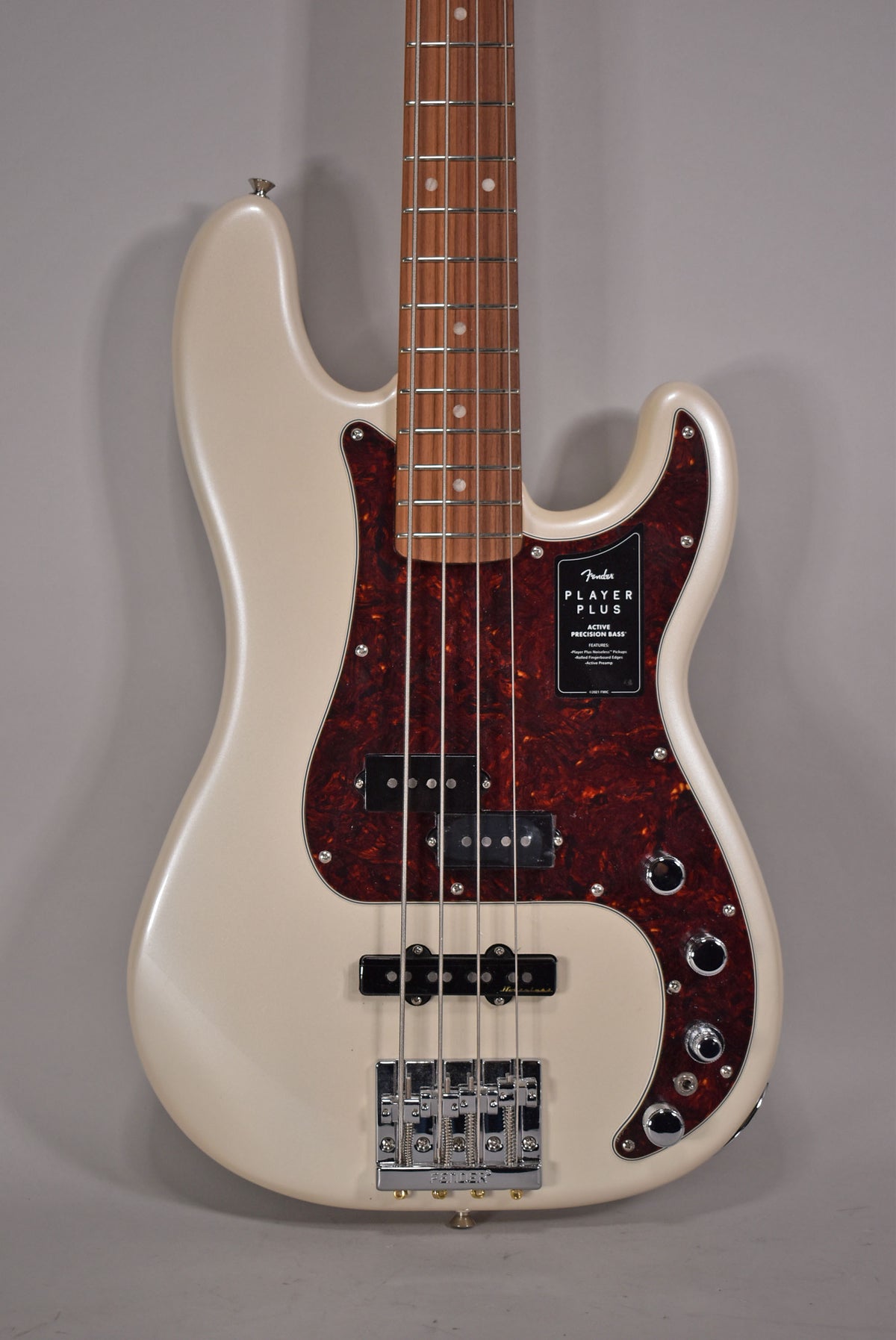 Full-frame view of an Olympic Pearl bass with a tortoiseshell pickguard, P/J pickups, and four chrome control knobs.