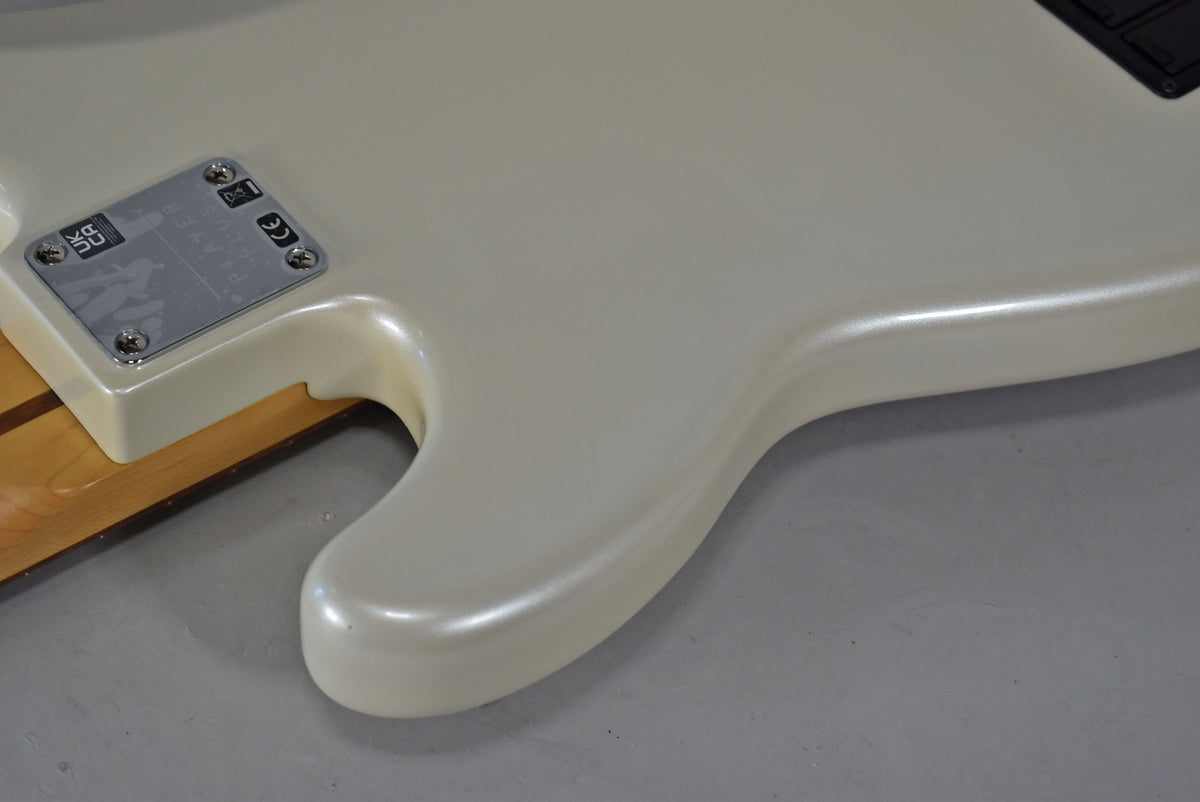 Close-up of the bass body's lower horn in Olympic Pearl, showing the neck plate and a hint of the maple neck.