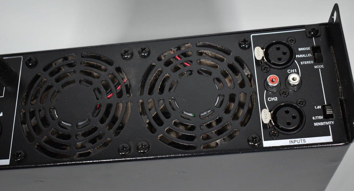 Rear view of the black amplifier, showing two large fan grilles, XLR and RCA inputs, and two toggle switches for mode and sensitivity.