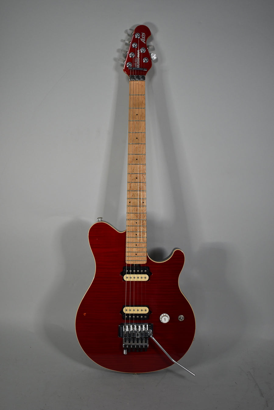 Full-length view of a trans red flame top electric guitar with a maple neck, two humbuckers, a Floyd Rose tremolo, and one volume knob.