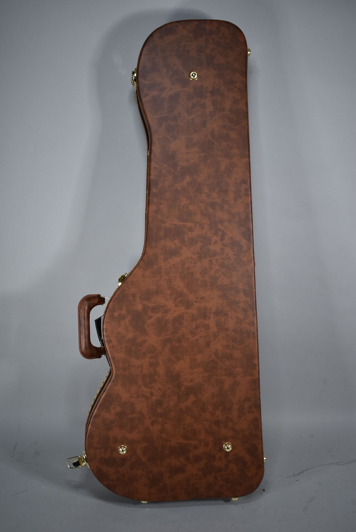 The brown faux-leather guitar case is shown from the side, revealing its handle, three gold latches, and four gold feet.