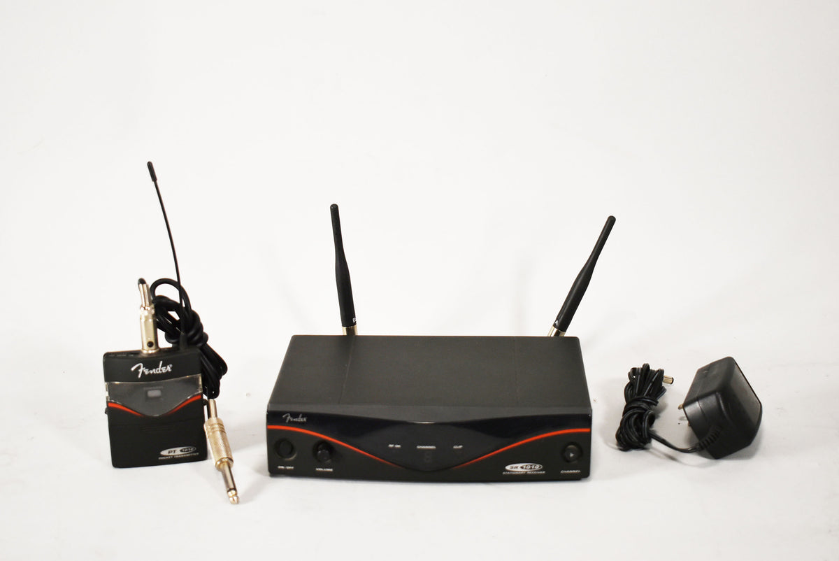 A black wireless system with a receiver, transmitter, and power adapter, all showing light wear.
