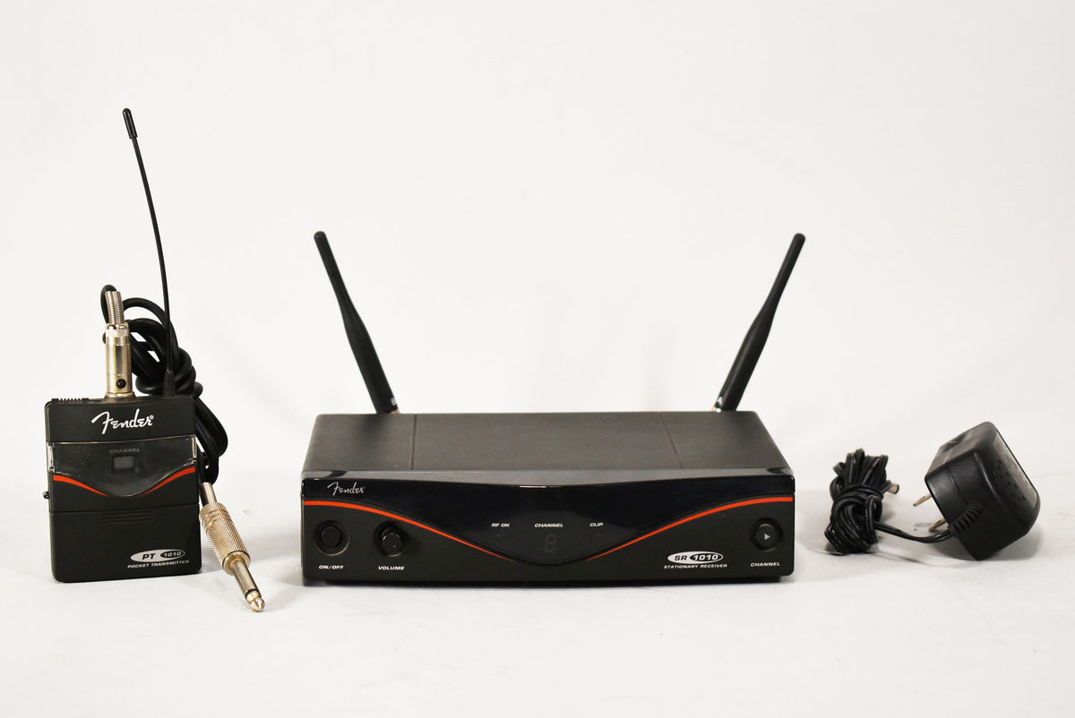 A black wireless system with a receiver, transmitter, and power adapter, all showing light wear.