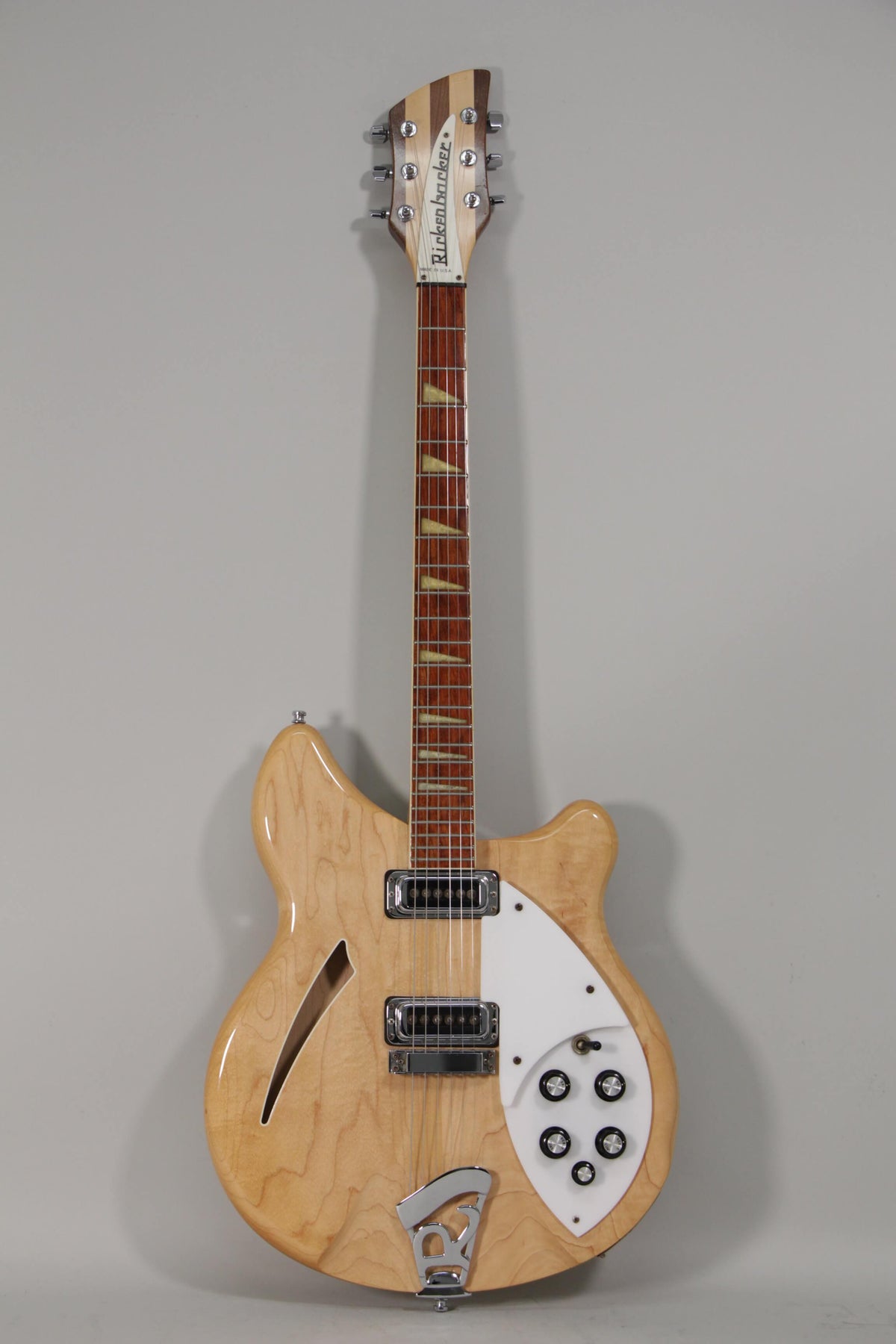 Full-length view of a glossy blonde hollow-body electric guitar with a white pickguard, chrome hardware, and black control knobs.