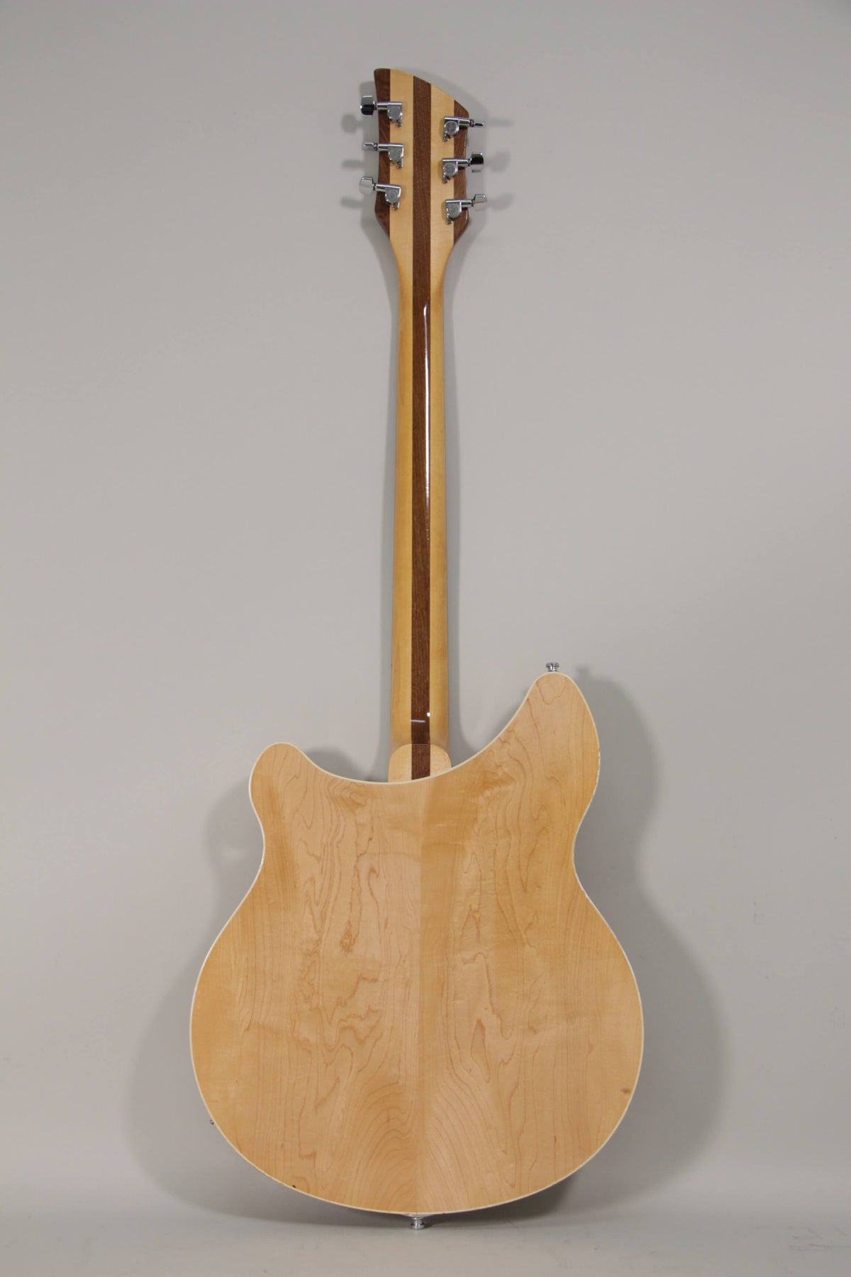 The guitar's back shows a light maple finish with a prominent grain, a two-tone neck, and six chrome tuners on the headstock.