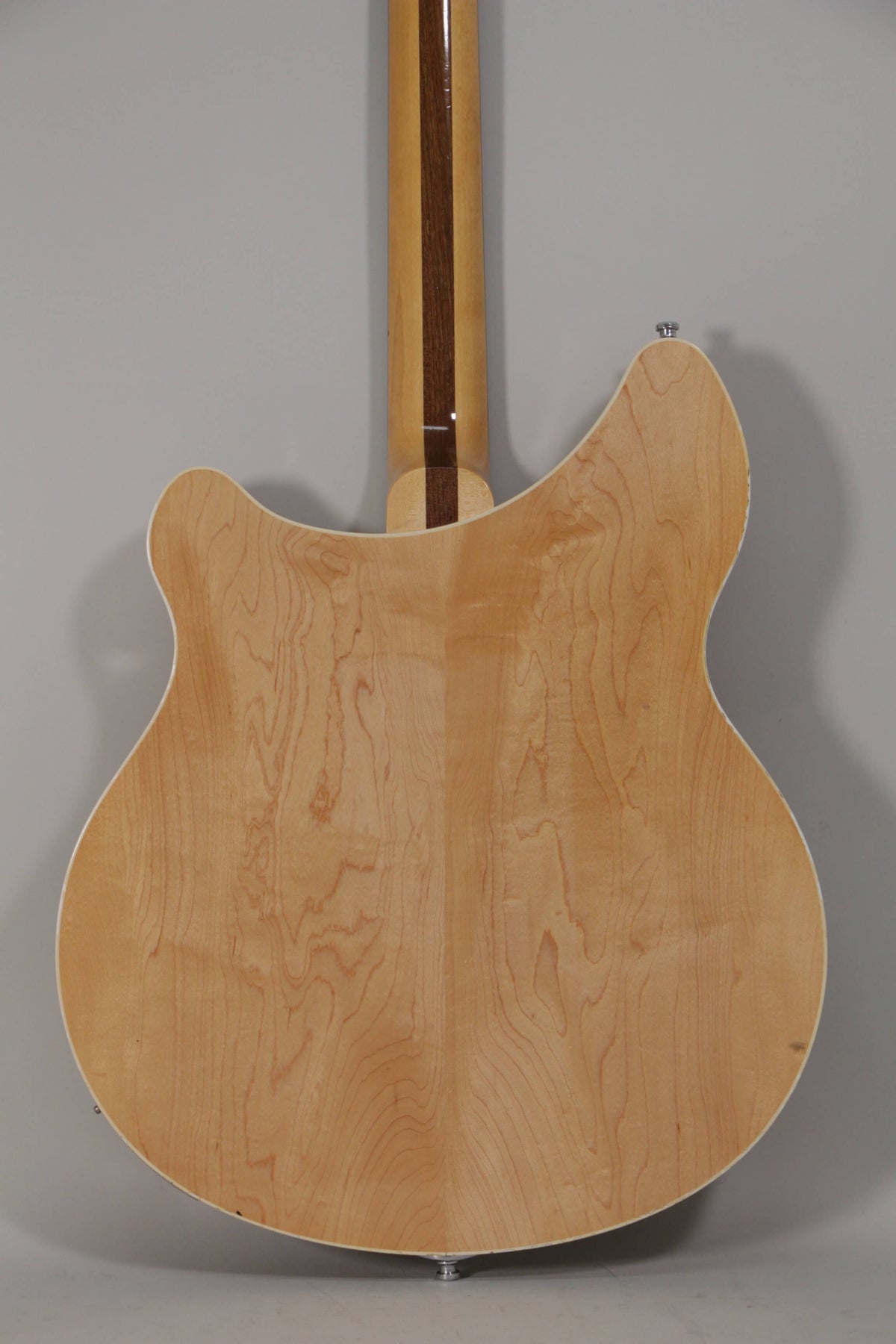 The guitar's light maple back and neck are visible, with a dark wood stripe down the center of the neck.