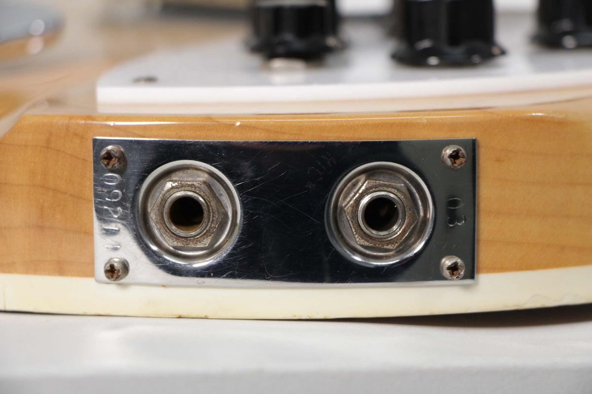 Close-up of the guitar's lower bout, showing two chrome output jacks on a metal plate, with light wear and tarnished screws.