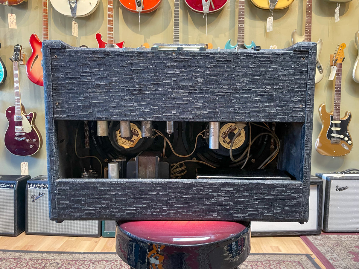 Rear view of a dark gray textured combo amp, showing exposed tubes, wiring, and two speakers with visible Jensen labels.