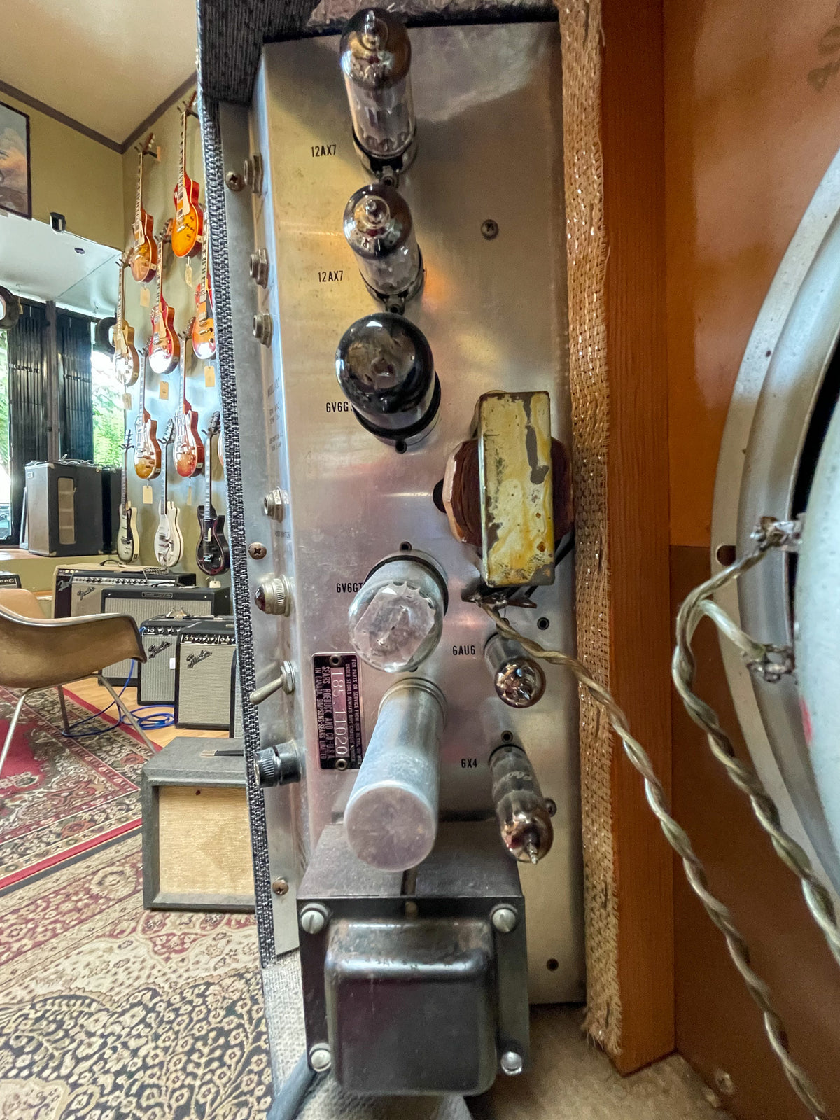 Close-up of the amp's silver chassis, showing several vacuum tubes, transformers, and wiring, with visible wear and oxidation.