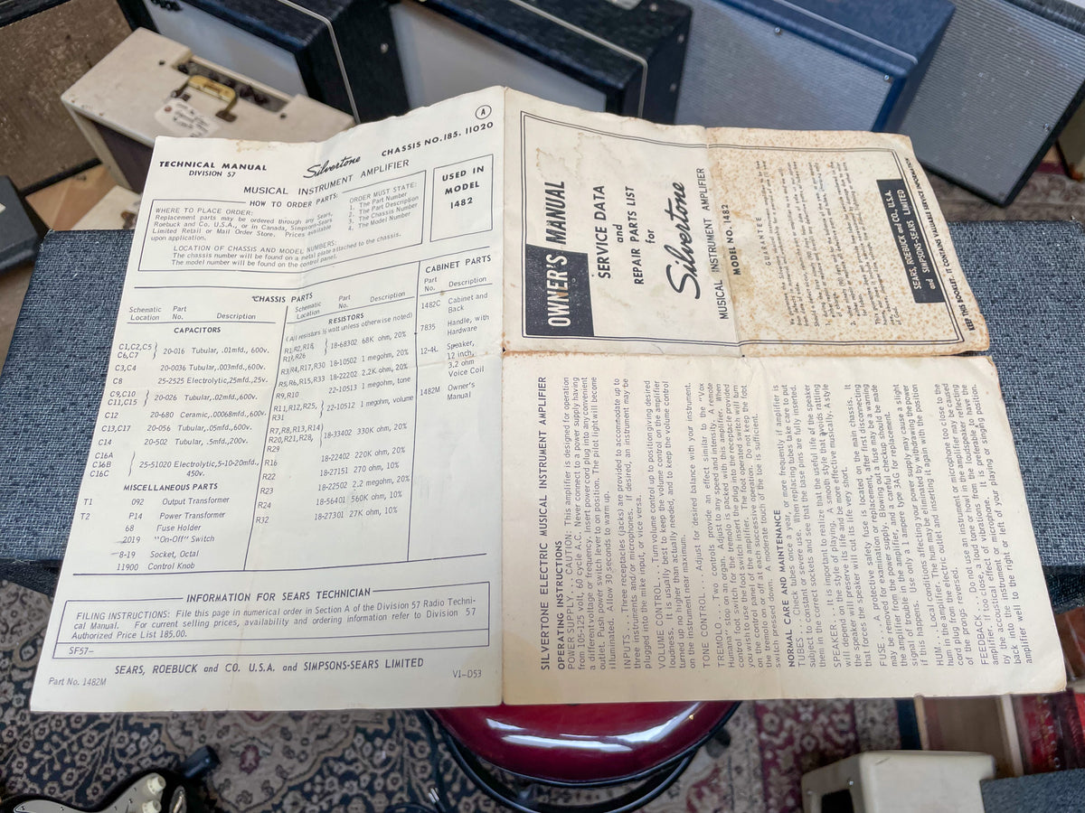 Two vintage Silvertone amplifier manuals, an owner's manual and a technical manual, lie open on a dark surface.