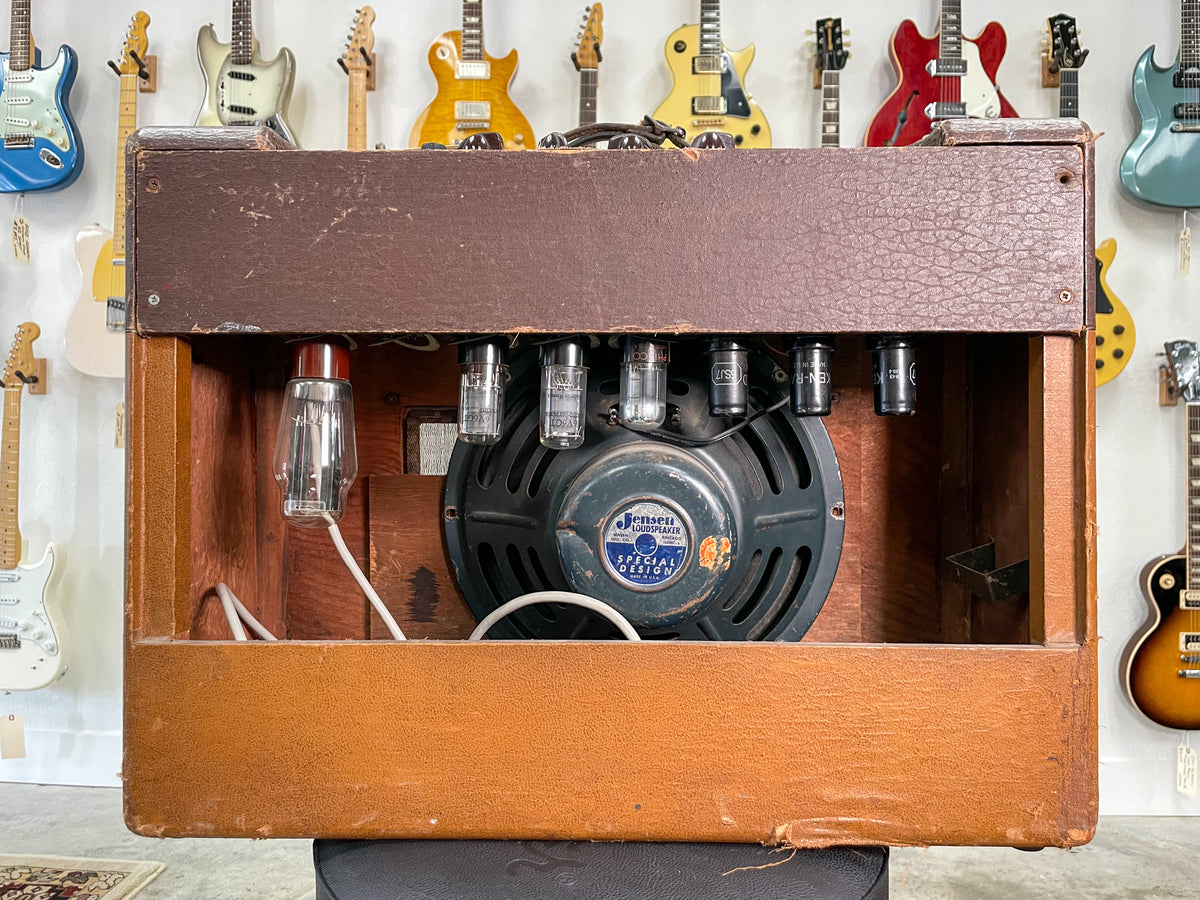 Rear view of a vintage combo amp with a brown textured top and tan sides, showing the exposed speaker, tubes, and wiring.
