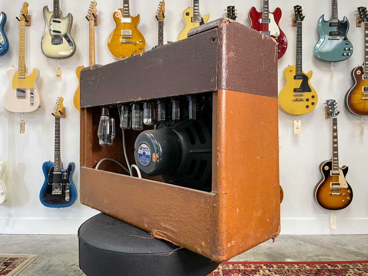 Right-side view of a two-tone brown amp, showing the open back with visible tubes, speaker, and worn, torn tolex.