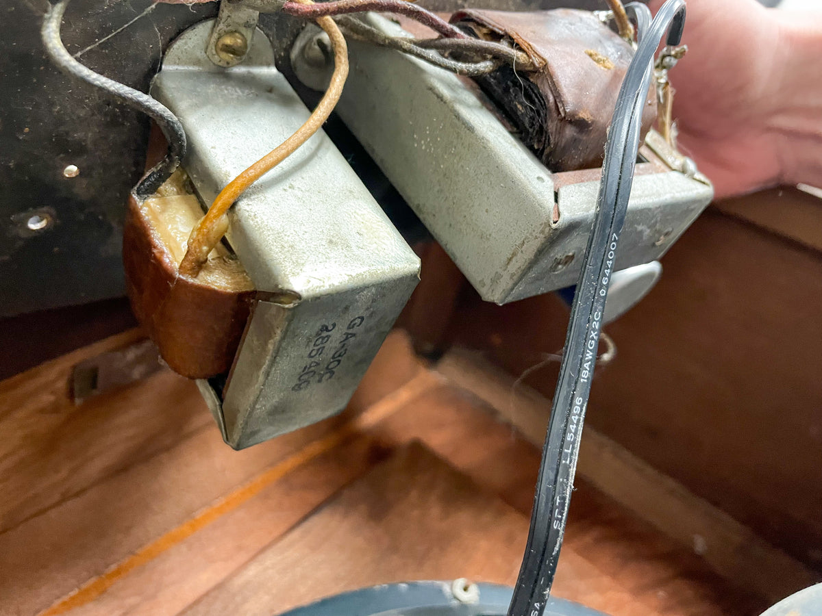 Close-up of the amp's internal components, showing two metal transformers with exposed brown wiring and a black power cable.