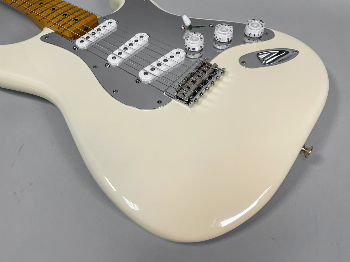 Upper body of an Olympic White Stratocaster, showing three single-coil pickups, chrome hardware, and white control knobs.