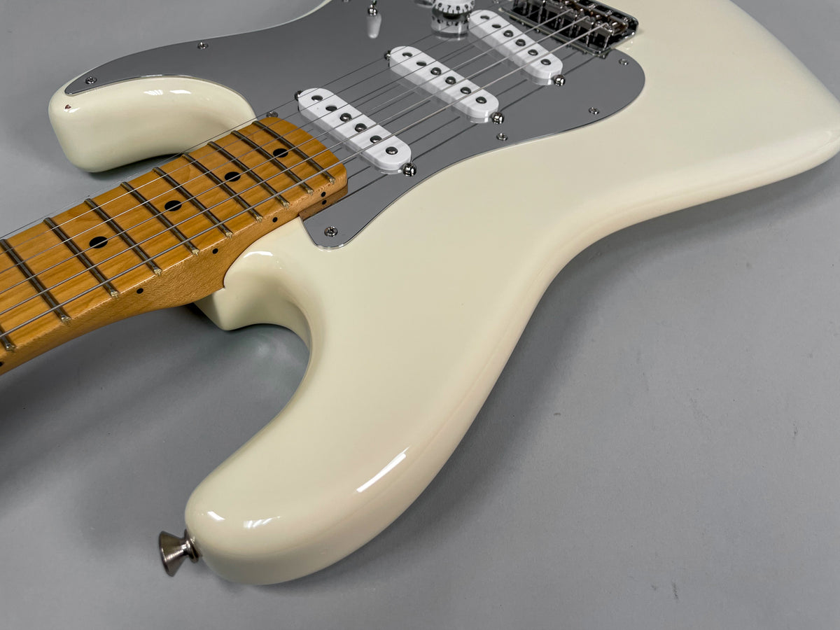 Upper body of an Olympic White Stratocaster, showing the maple fretboard, three single-coil pickups, and chrome pickguard.