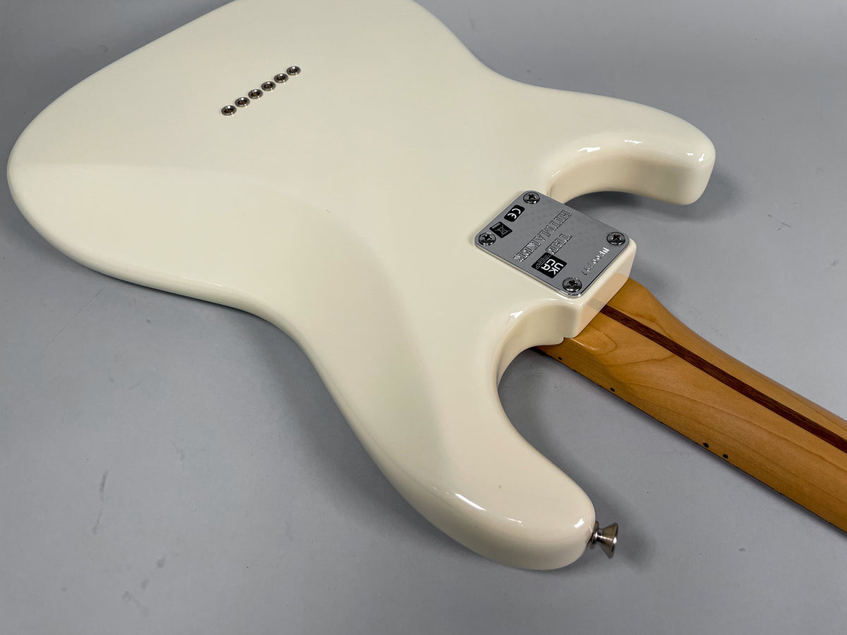 Back of an Olympic White Stratocaster body, showing the neck plate, six string ferrules, and the lower strap button.