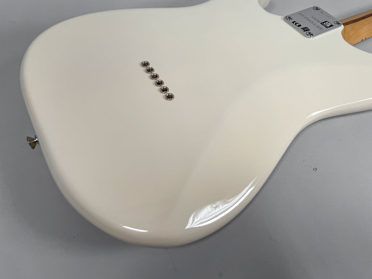 The back of an Olympic White Stratocaster body, showing six string-through-body ferrules and a chrome strap button.