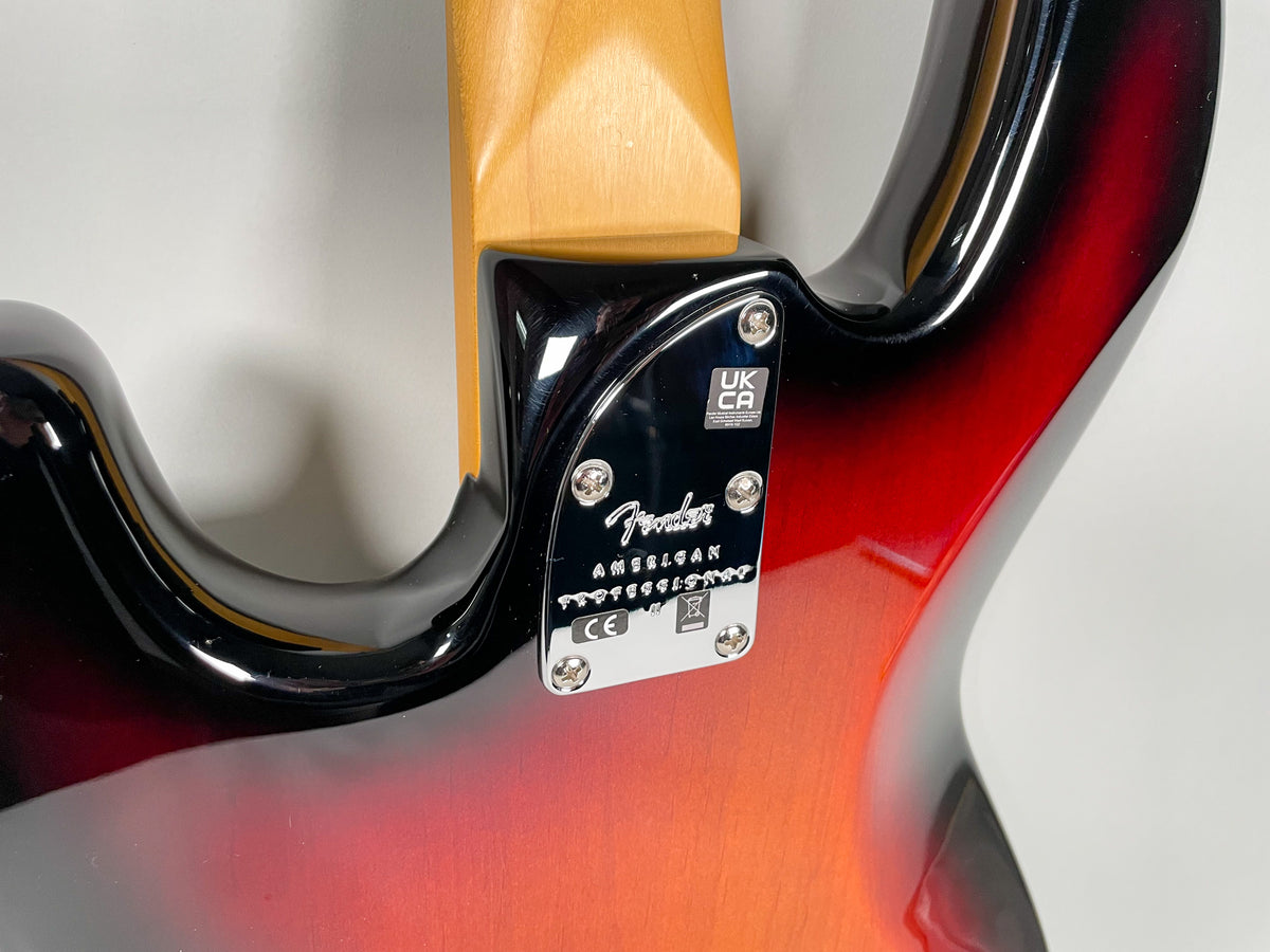The bass's sunburst body and maple neck meet at a chrome neck plate with four screws, viewed from the back.