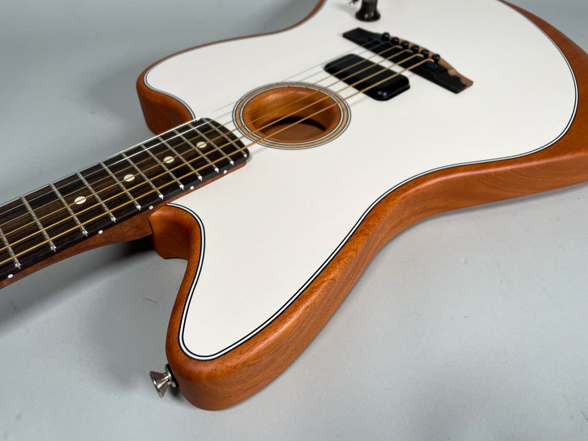 The Arctic White Jazzmaster body, with a natural wood back and sides, is angled to show the fretboard and soundhole.