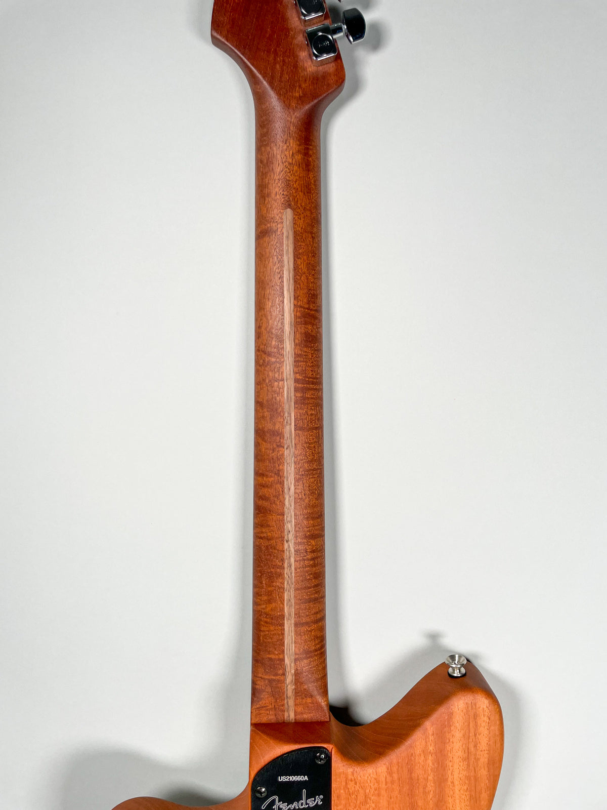 The back of the guitar's neck and upper body, showing a rich, reddish-brown wood grain with a lighter stripe down the center of the neck.