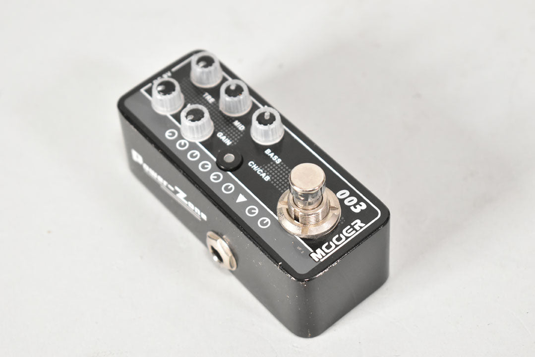 Black micro preamp pedal, angled from above, showing six clear knobs, a silver footswitch, and a 1/4" input jack.