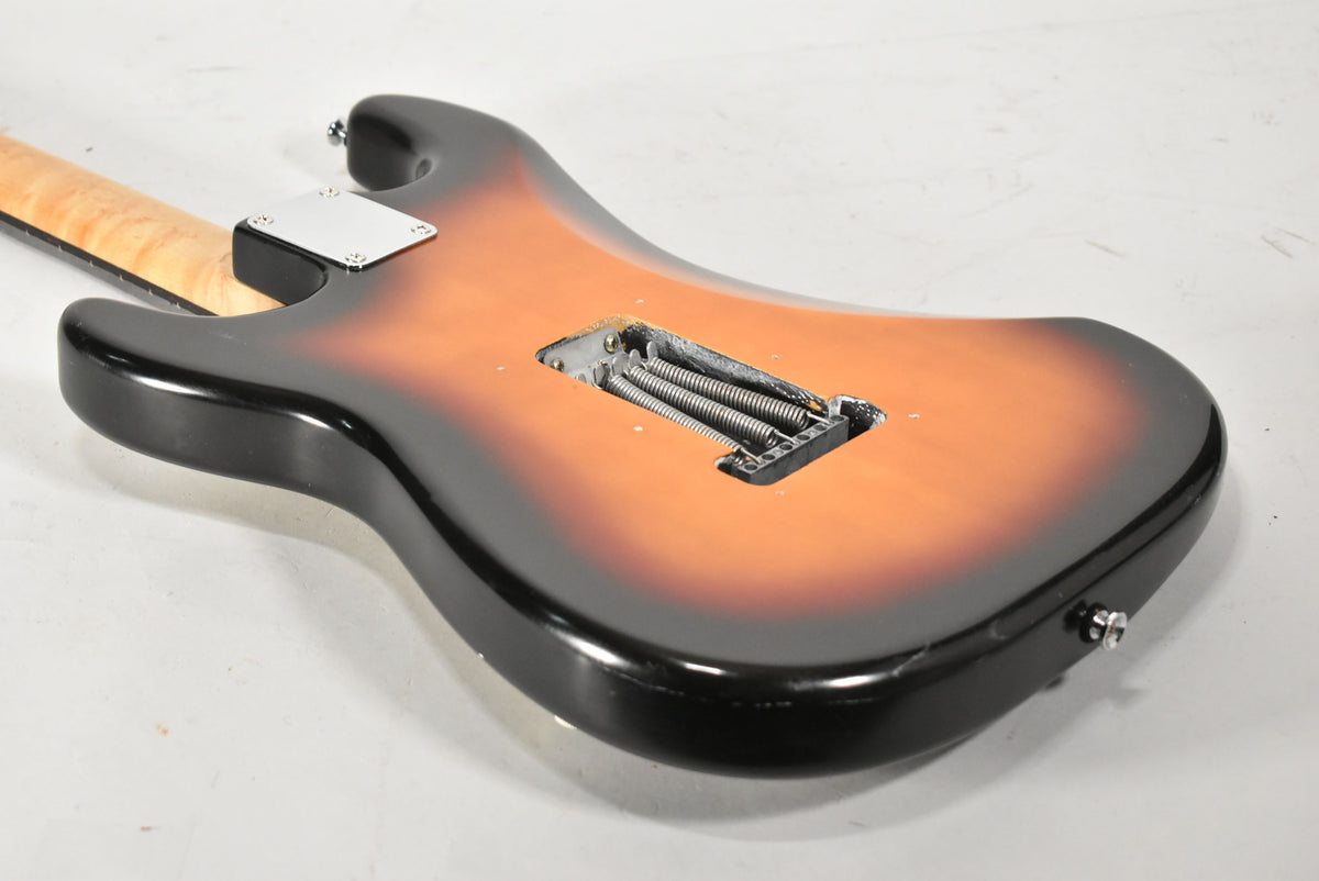 The back of a sunburst Strat-type guitar, showing the tremolo spring cavity, neck plate, and a few small dings on the body.