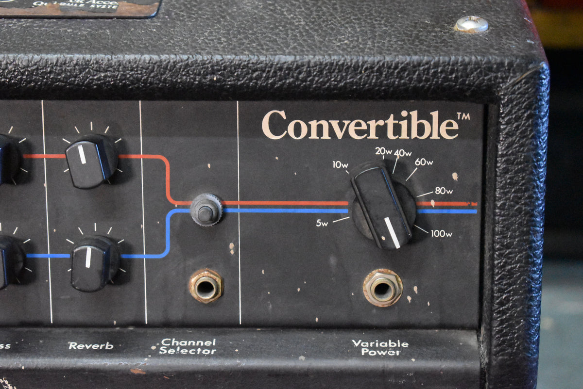 Close-up of the amp's black control panel, showing a large variable power knob, channel selector switch, and two input jacks.