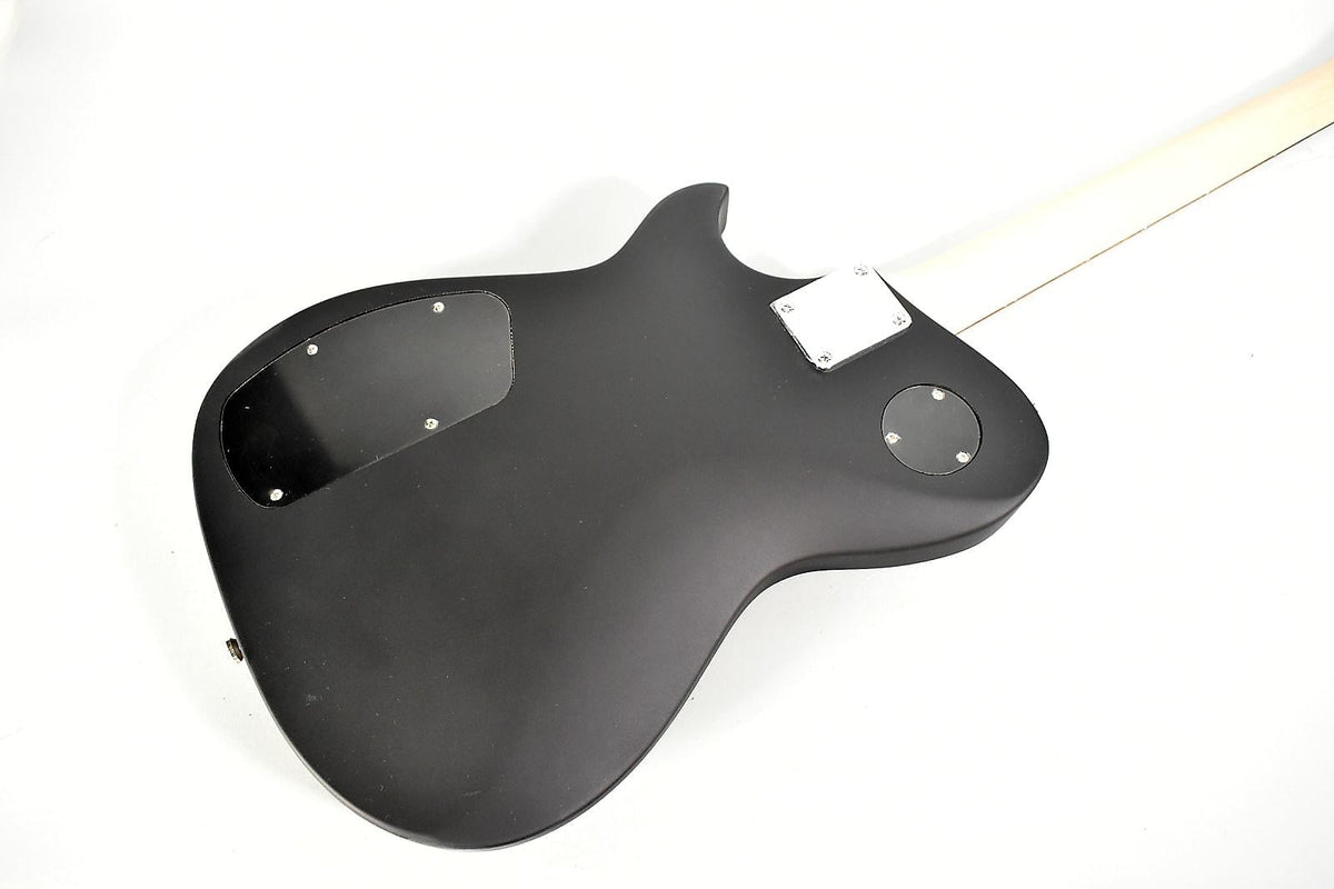 The guitar's matte black back, with two control cavity covers and a chrome neck plate, angles up to a light-colored neck.