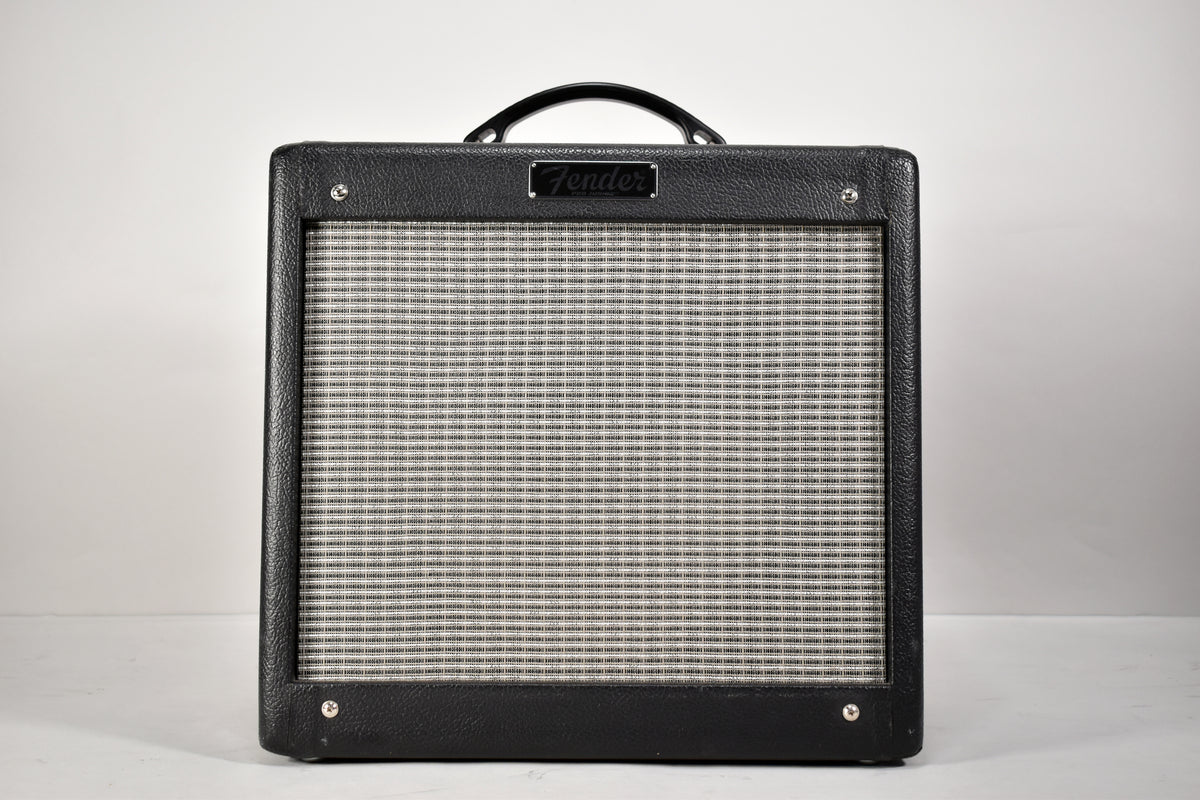 Front view of a black textured combo amp with a silver grille, black handle, and four visible corner protectors.
