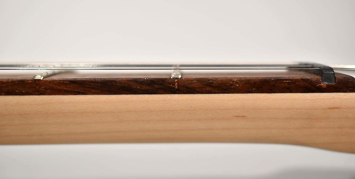 A close-up side view of the guitar neck, showing the dark wood fretboard, light wood neck, and metal frets and strings.