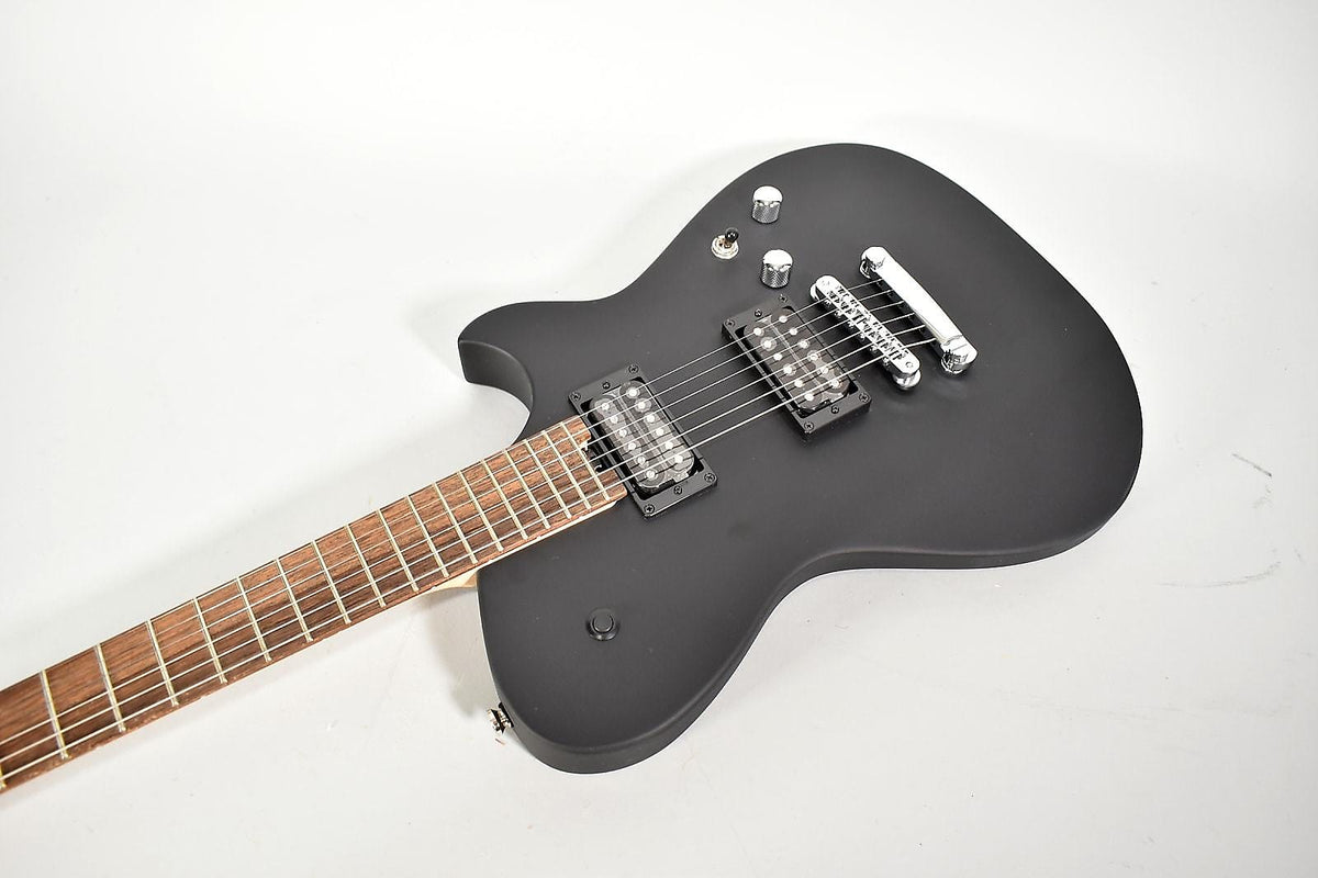 Matte black electric guitar, angled from the neck to the lower bout, showing two humbuckers and chrome hardware.