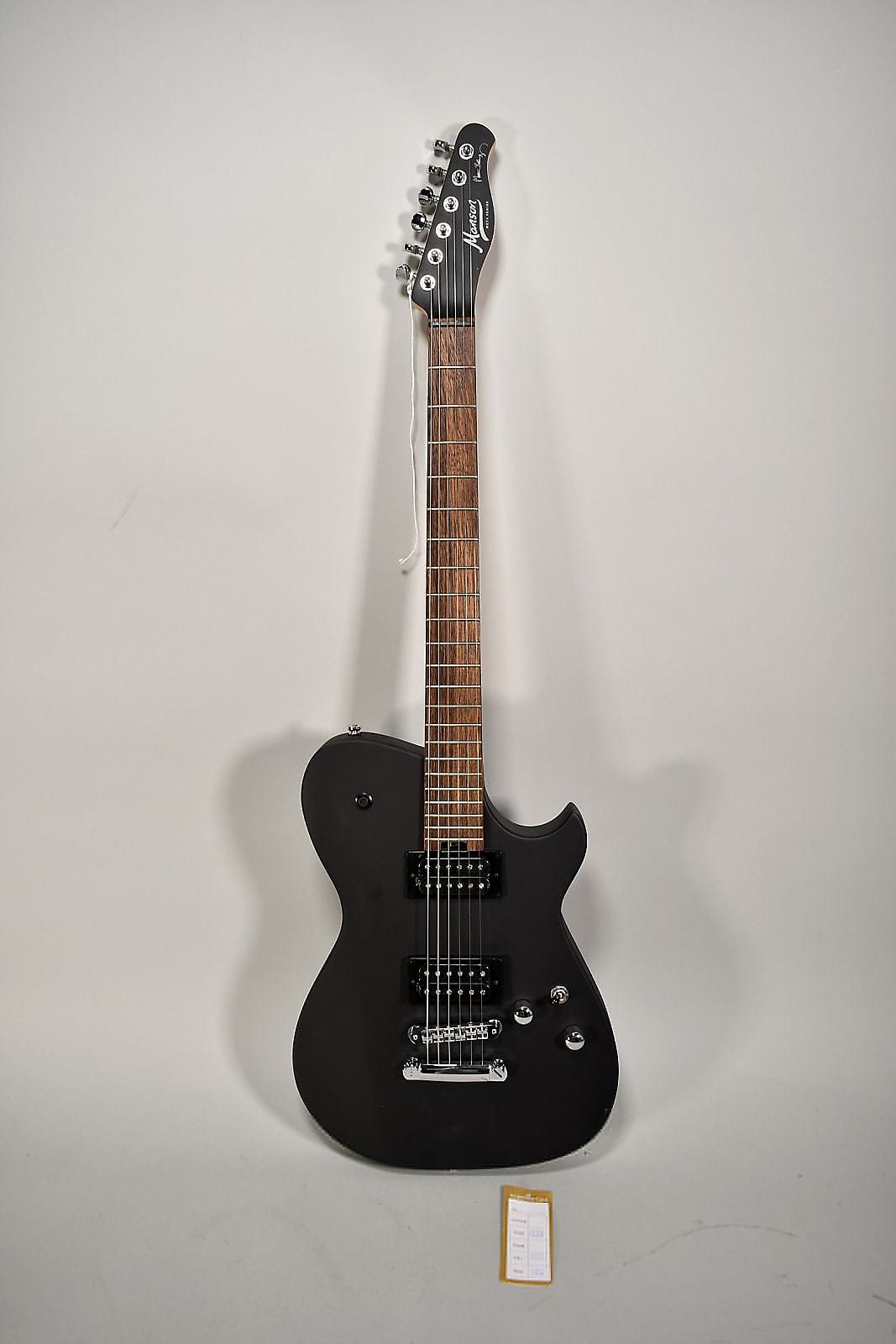 Full-length view of a matte black electric guitar with a dark brown fretboard, two humbucker pickups, and chrome hardware.